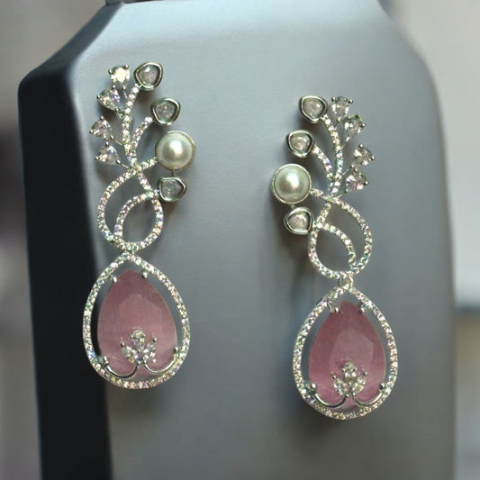 Beautiful American Diamond Statement Earrings In pinkish Shade placed on a grey coloured jewellery display stand with a leaves design.