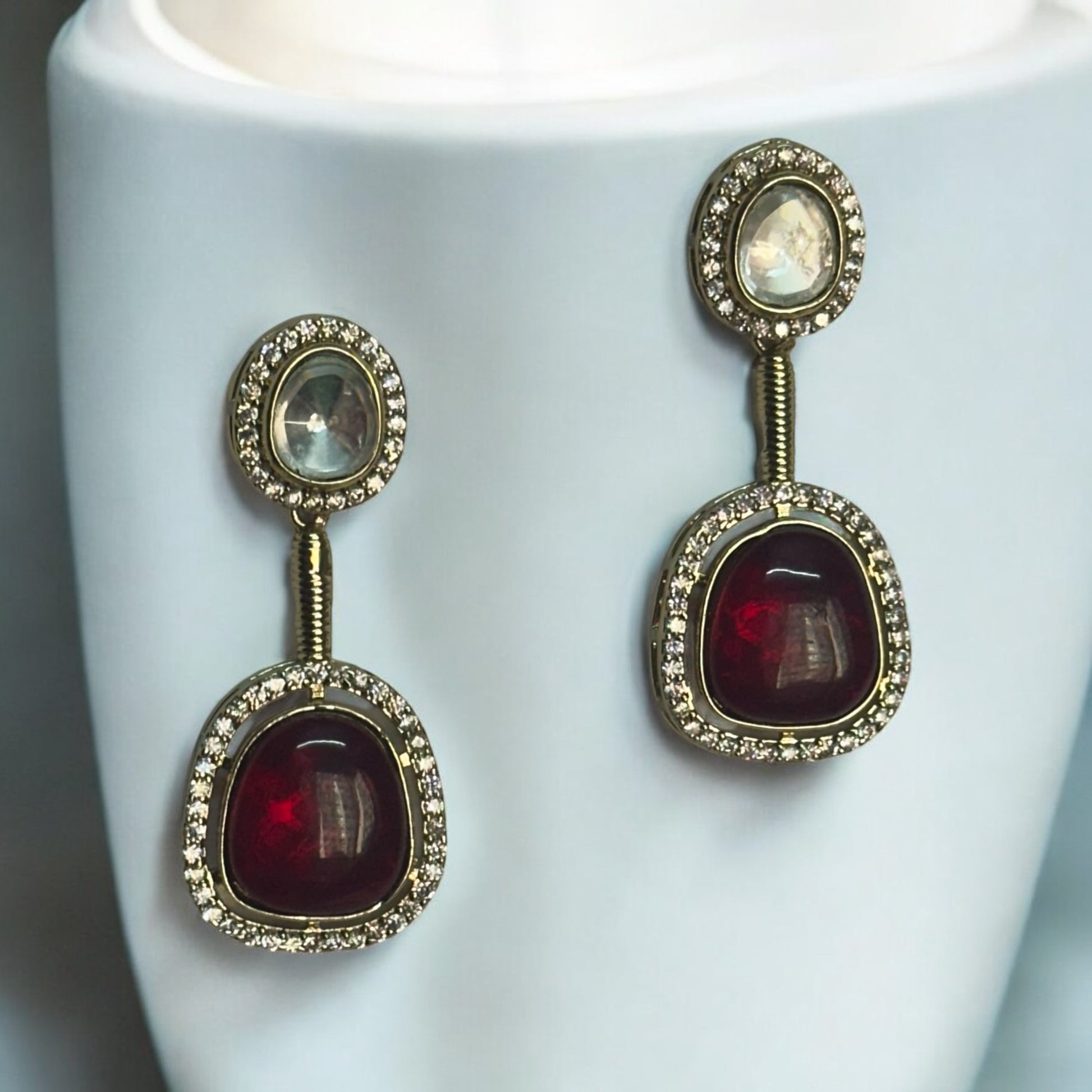 Elegant designer polki kundan teardrop accents and red gemstone centerpiece matching earrings.