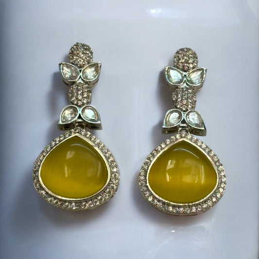 Elegant American Diamond Yellow Partywear Earrings with teardrop yellow stones and shimmering leaf-shaped studded accents.