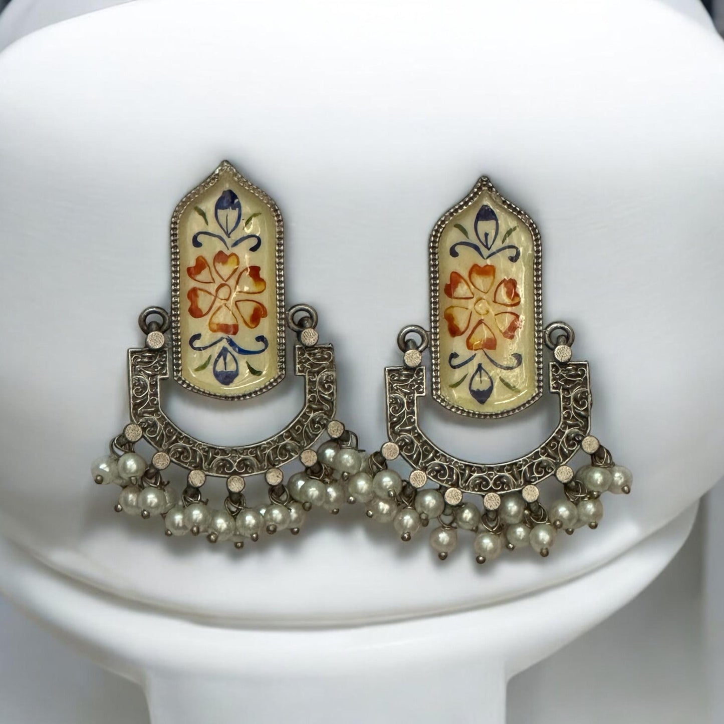 Fusion Hand Painted Statement Earrings with intricate floral motifs, vintage silver detailing, and pearl embellishments, displayed on a white stand.