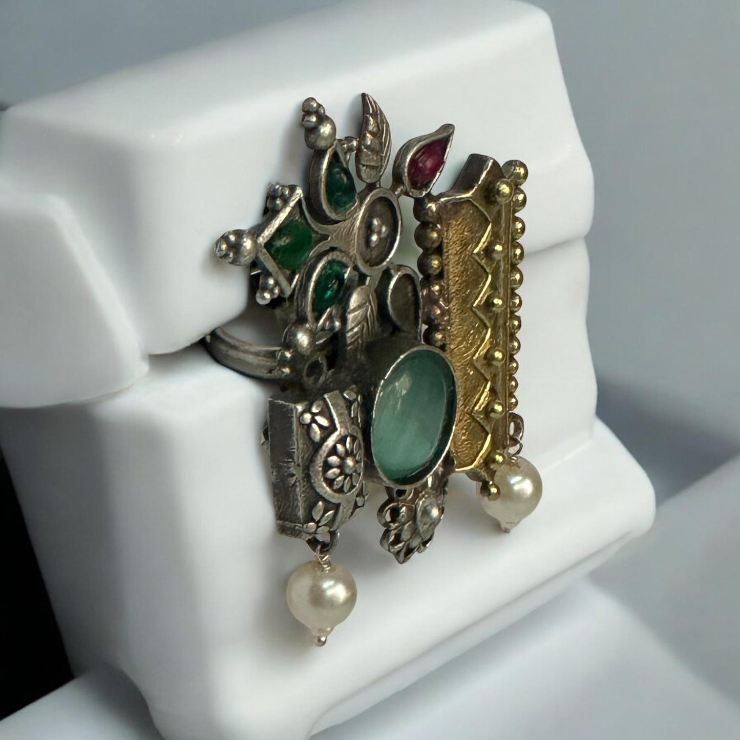 Side view of Fusion Designer Finger Ring with a mix of gold-plated and oxidized silver motifs, featuring green and red stones, floral designs, and pearl drops, displayed on a white background.