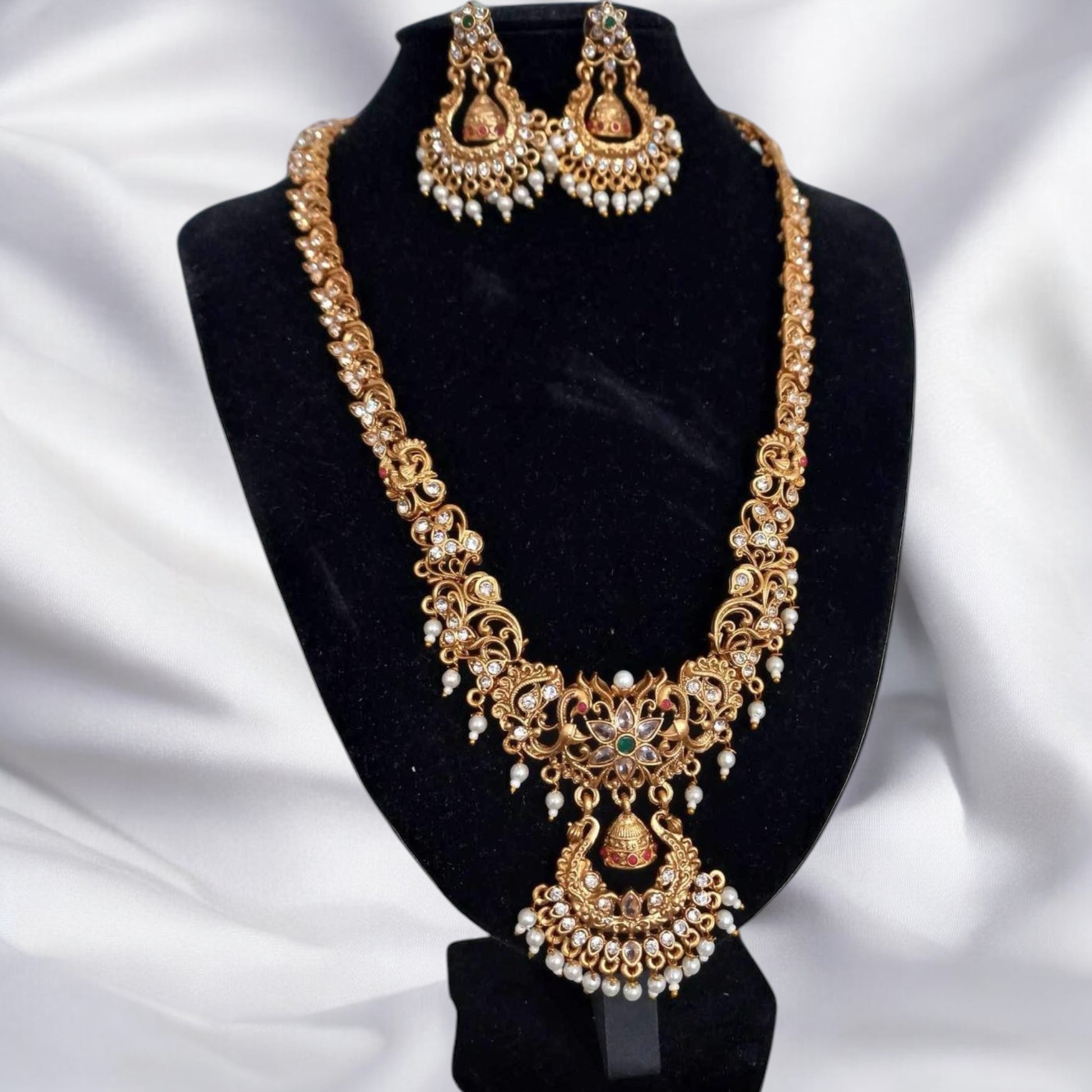 Gold-Plated Temple Necklace with Earrings – intricately designed gold-plated necklace featuring temple-inspired motifs, pearl drops, and matching earrings. Perfect for weddings and cultural events.