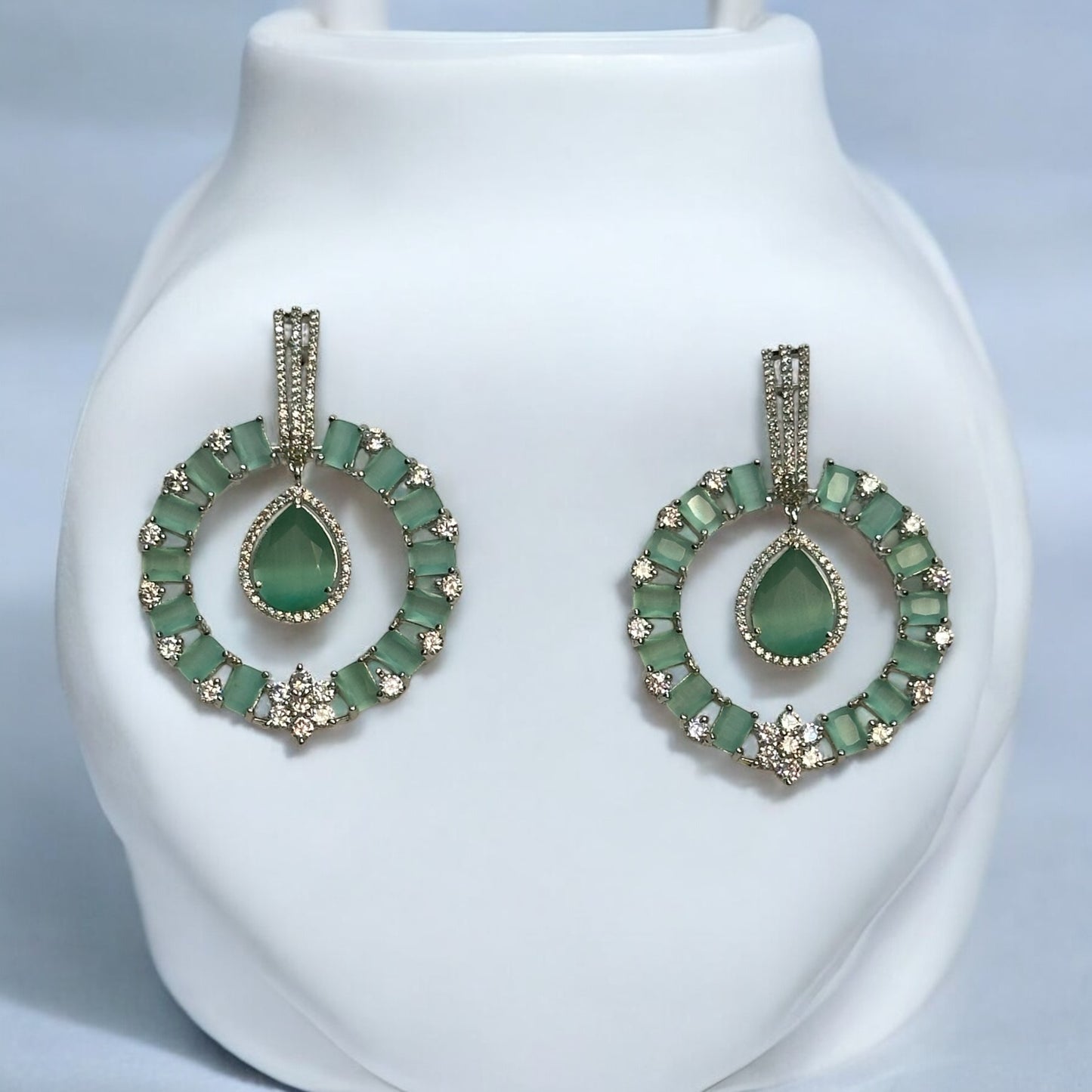 Premium American Diamond Light Green Earrings – circular earrings featuring light green stones, teardrop centerpieces, and sparkling American diamonds. Perfect for weddings and festive occasions.