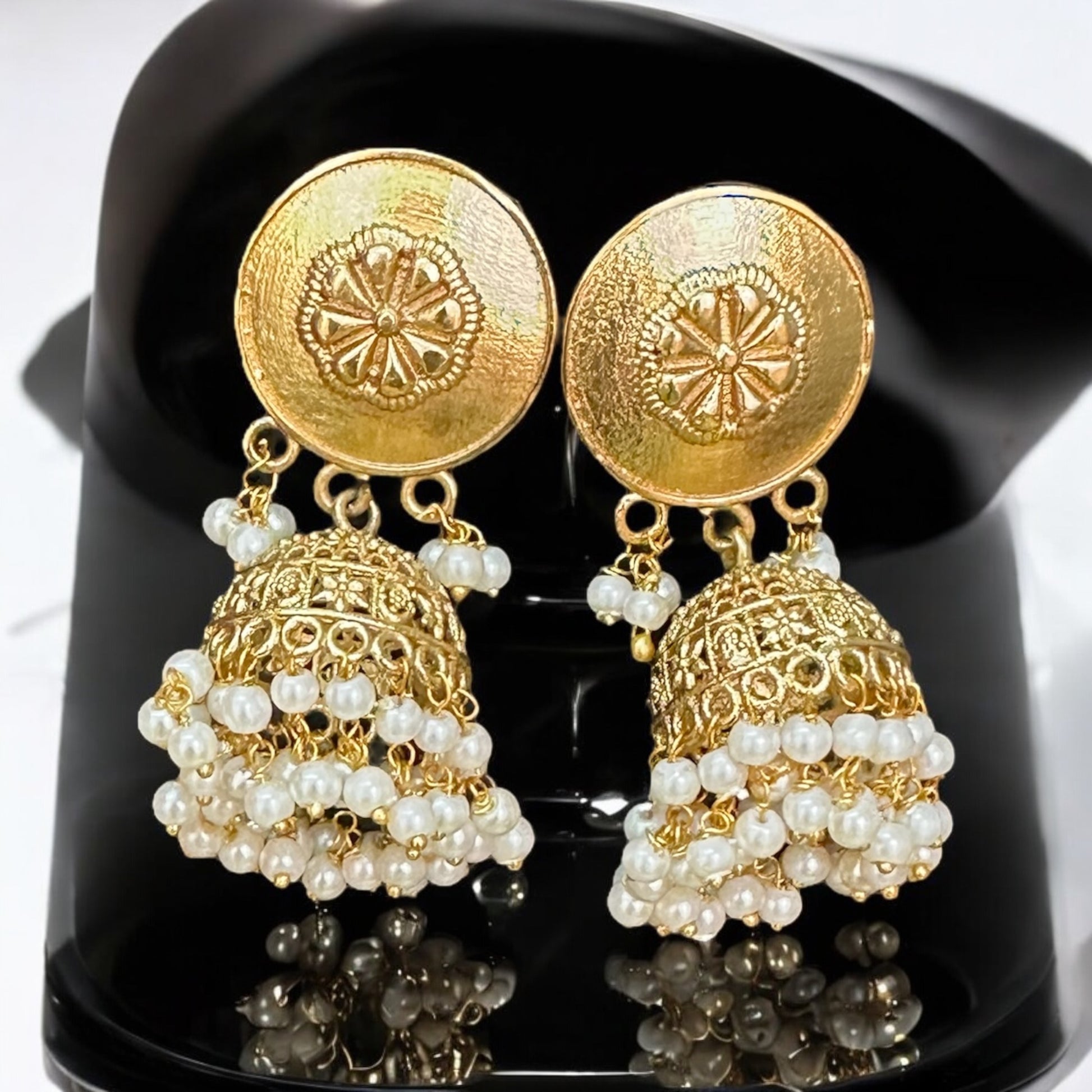 Premium designer Amrapali gold-toned Earrings with pearl drop design, displayed on a black jewelry bust with a soft white background.