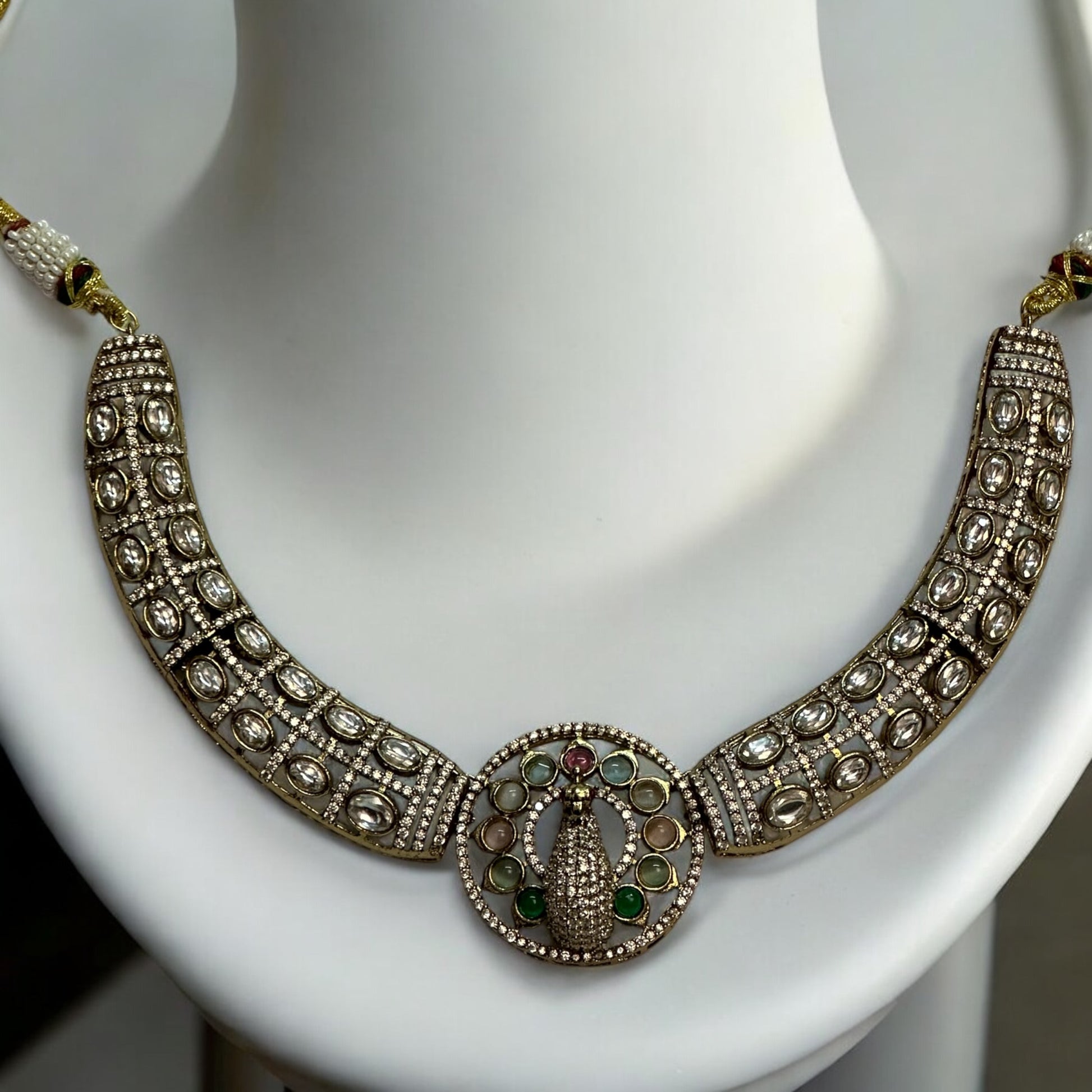 Premium Hasli Kundan Necklace and with a peacock design, Placed on a white coloured jewellery display stand.