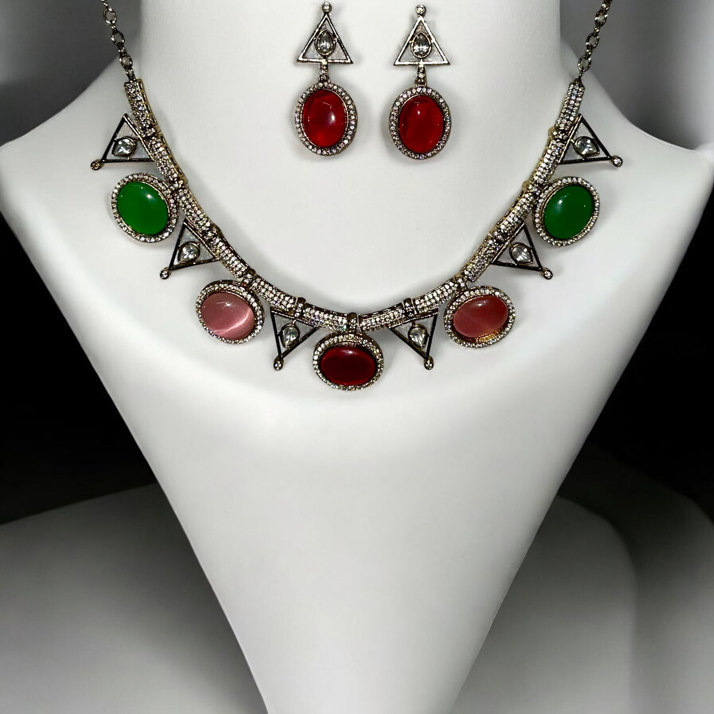 Premium Moissanite Diamond Multicolour Necklace Set with red, green and pink stones embedded. It is placed on a white jewellery display stand.