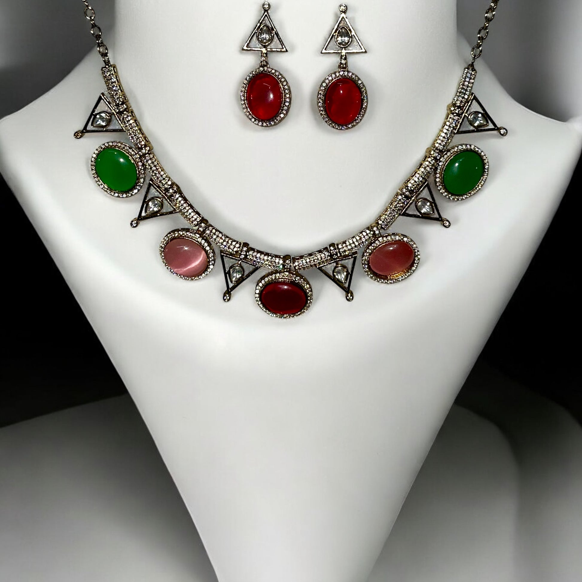 Premium Moissanite Diamond Multicolour Necklace Set with red, green and pink stones embedded. It is placed on a white jewellery display stand.