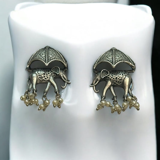 Silver Replica Elephant Design Earrings featuring intricate detailing of elephants under ornate umbrellas with dangling pearl accents, displayed against a white background.