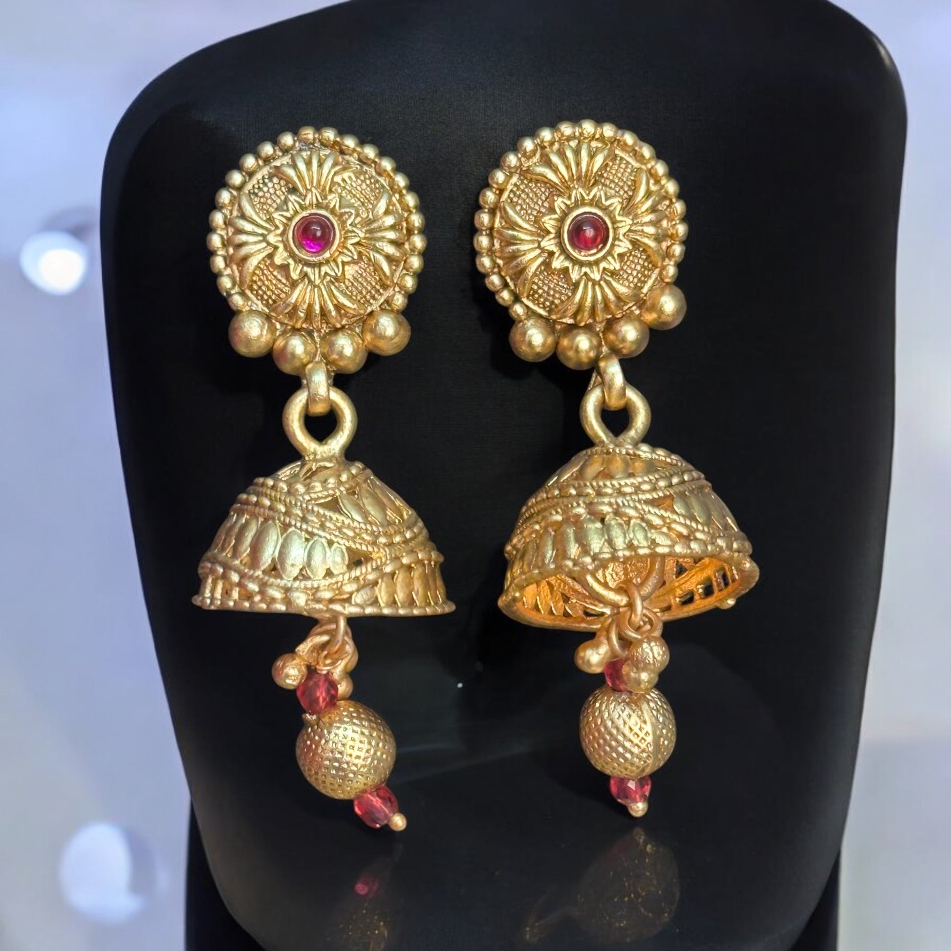 Rajawadi Kundan Choker's matching Jhumki Earrings – gold-tone with intricate kundan work, pearls, cascading mesh detailing placed on a black jewellery display stand. Ideal for weddings and festive occasions.