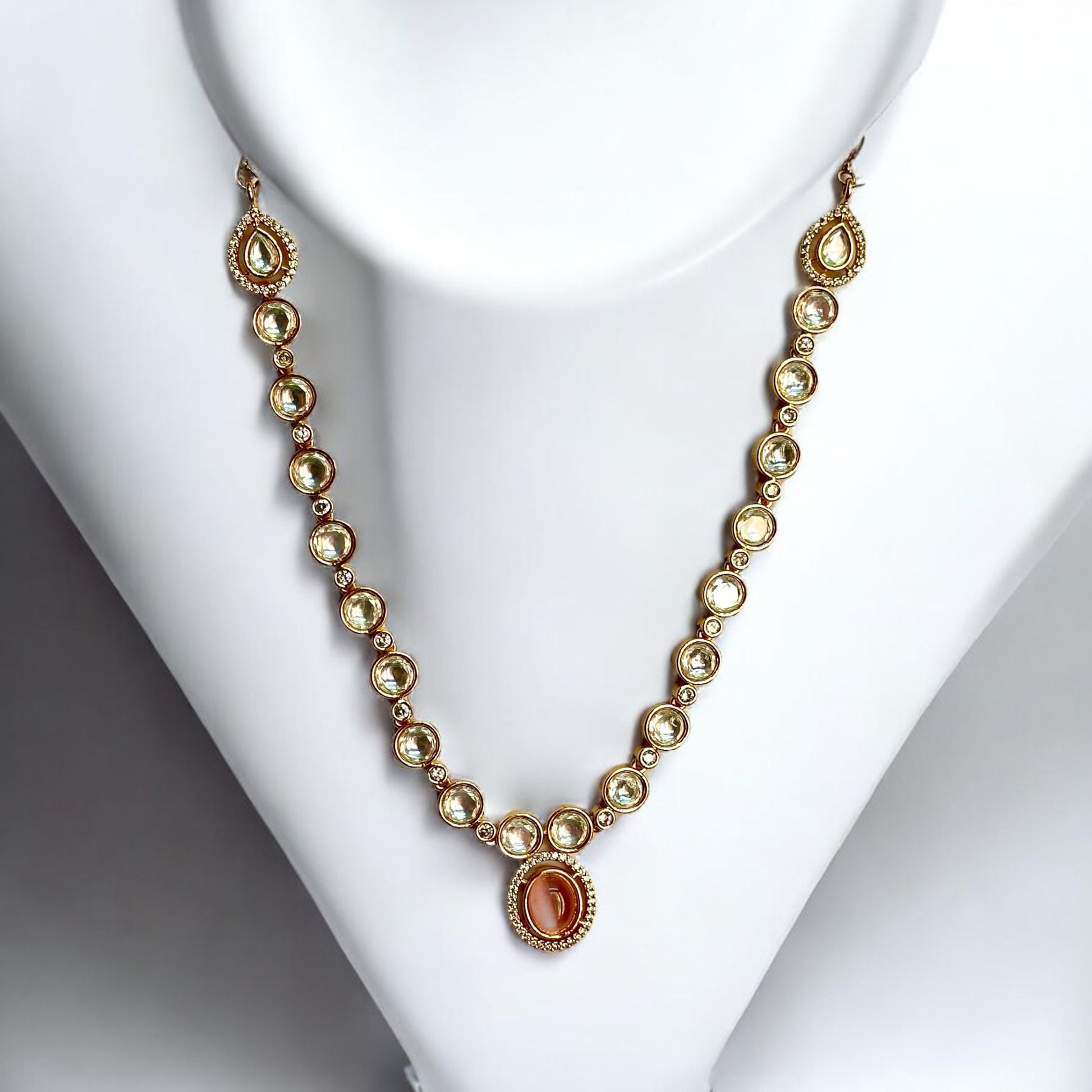 Premium Polki Kundan Necklace featuring an elegant gold-tone design with intricate Polki stones, placed on a white coloured jewellery display stand. Perfect for weddings, festive occasions, and traditional attire. Available now on our bella & Diva website